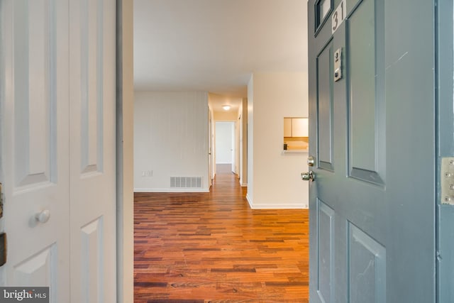 entrance foyer featuring baseboards, visible vents, and wood finished floors