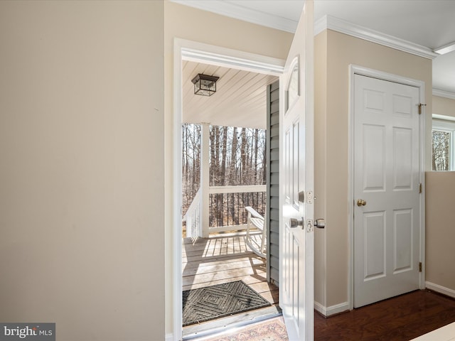 doorway to outside with wood finished floors, baseboards, and ornamental molding