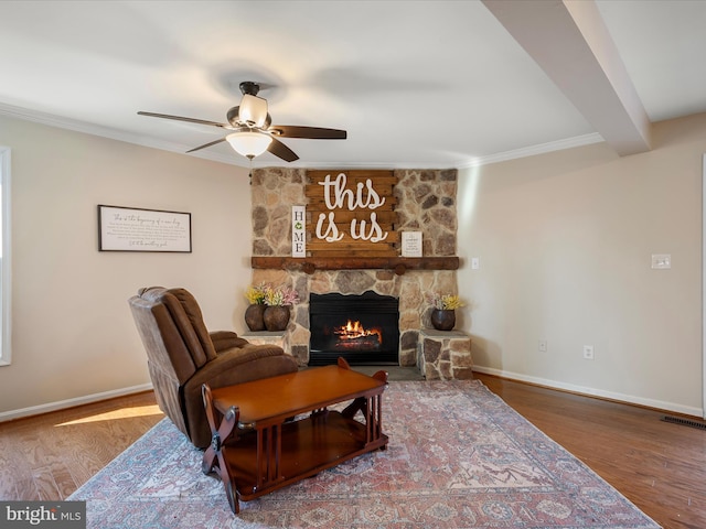 living area with visible vents, baseboards, wood finished floors, and a fireplace