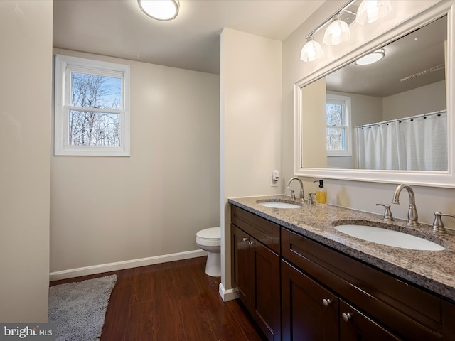 full bathroom featuring a sink, a wealth of natural light, baseboards, and wood finished floors