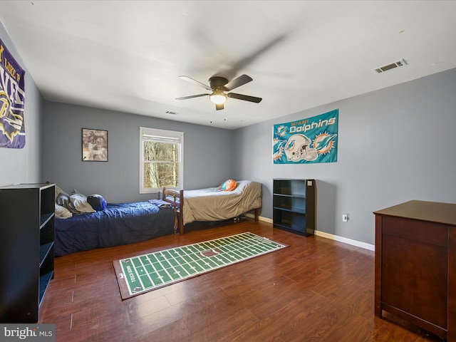 bedroom with visible vents, baseboards, wood finished floors, and a ceiling fan