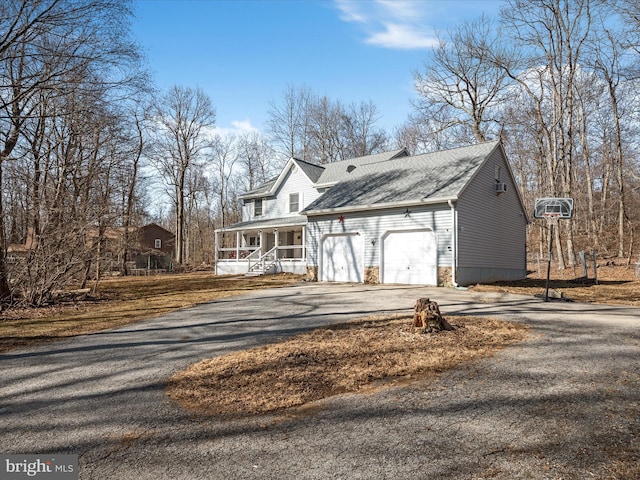 view of front of property featuring a porch, an attached garage, roof with shingles, and aphalt driveway