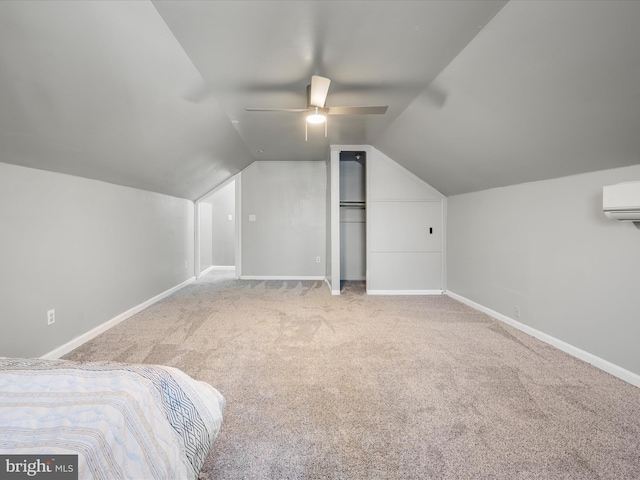 unfurnished bedroom with a wall mounted air conditioner, carpet flooring, baseboards, ceiling fan, and vaulted ceiling