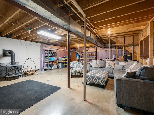 unfinished basement featuring a wood stove