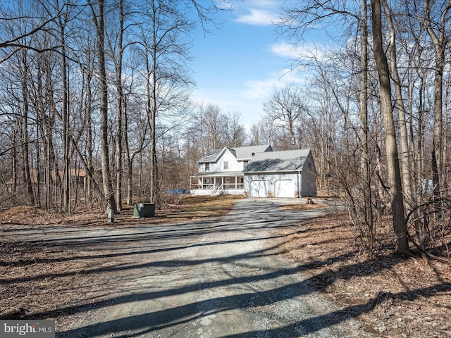 view of front of home featuring a garage, covered porch, and driveway