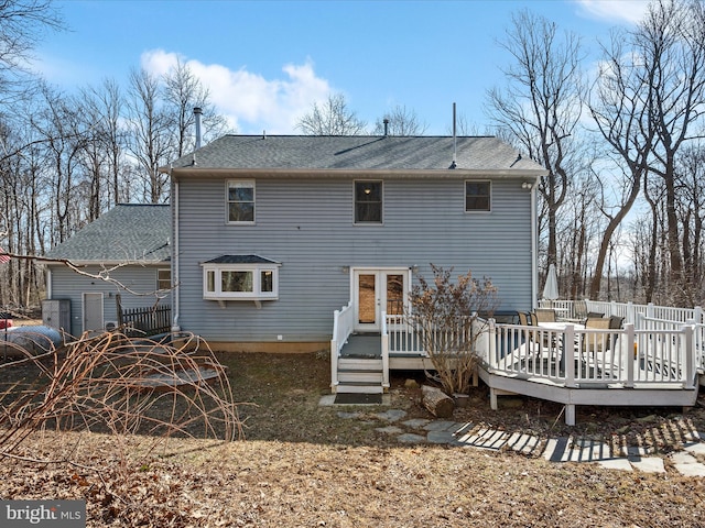 rear view of property featuring french doors, a deck, and fence