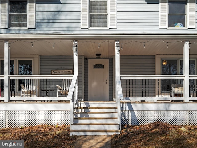 view of exterior entry featuring covered porch