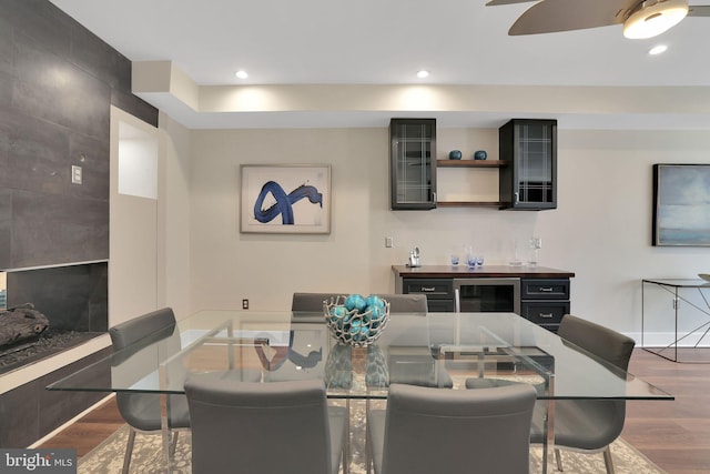 dining space featuring beverage cooler, ceiling fan, wood finished floors, and recessed lighting