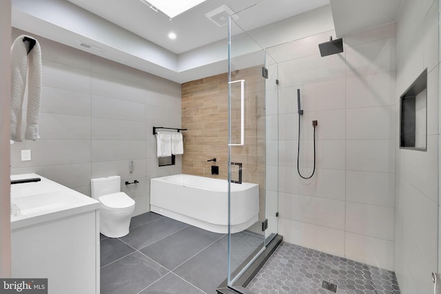 full bathroom featuring a washtub, a shower stall, tile walls, and tile patterned floors