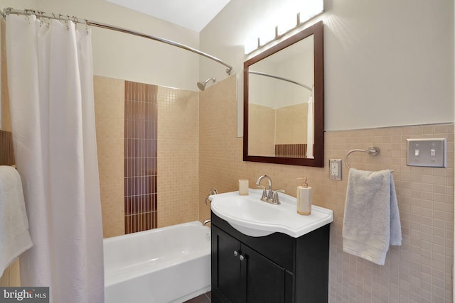 bathroom with shower / bathtub combination with curtain, tile walls, and vanity