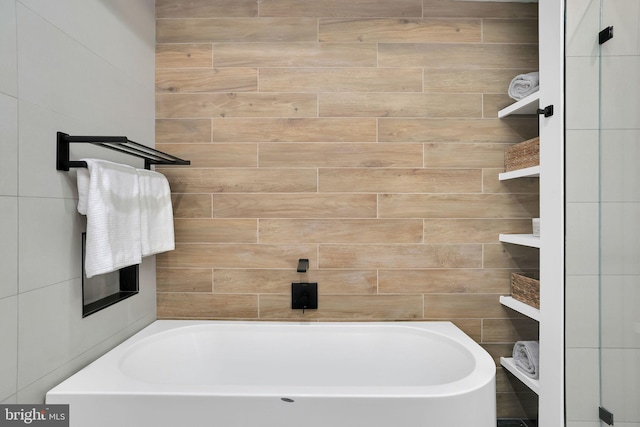 full bath with a tub to relax in and tile walls