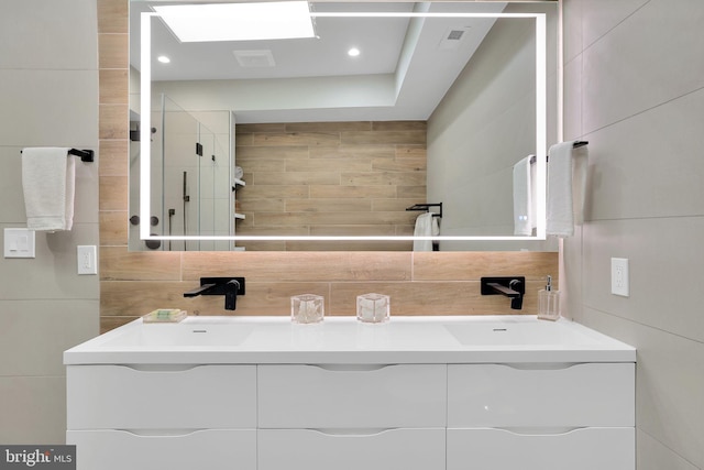 bathroom featuring visible vents, tile walls, vanity, backsplash, and recessed lighting