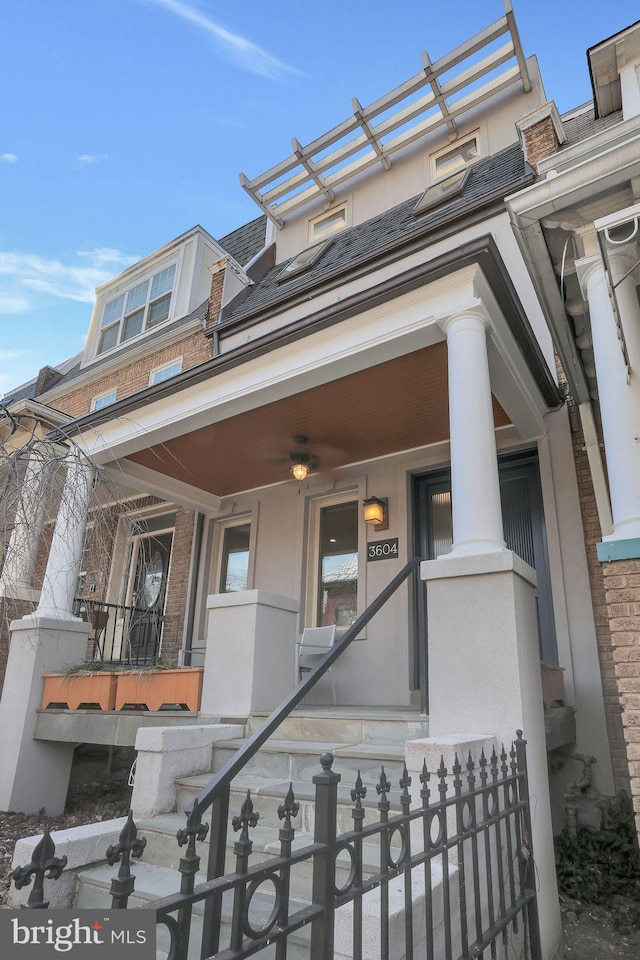 view of front of house featuring covered porch, a fenced front yard, and brick siding