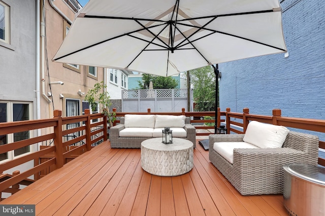 deck featuring an outdoor hangout area and fence