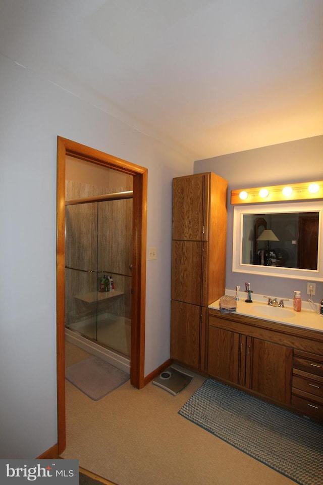 full bathroom featuring a stall shower, vanity, and baseboards