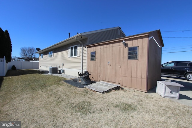 back of house with a lawn, fence, and central air condition unit