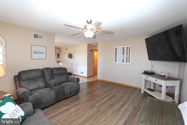 living area with ceiling fan, wood finished floors, visible vents, and baseboards