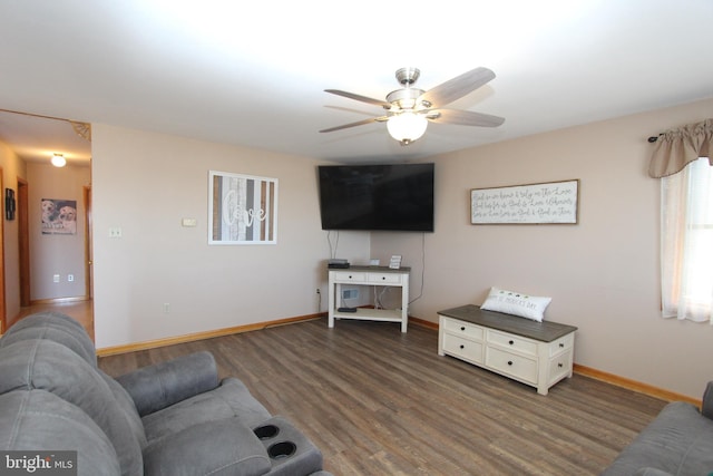 living area featuring a ceiling fan, baseboards, and wood finished floors