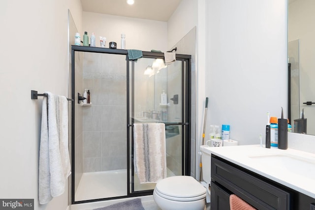 full bath featuring toilet, a stall shower, and vanity