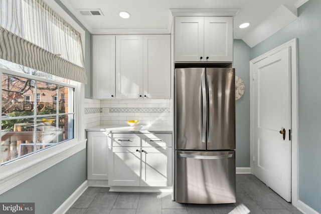 kitchen featuring visible vents, white cabinetry, light countertops, and freestanding refrigerator