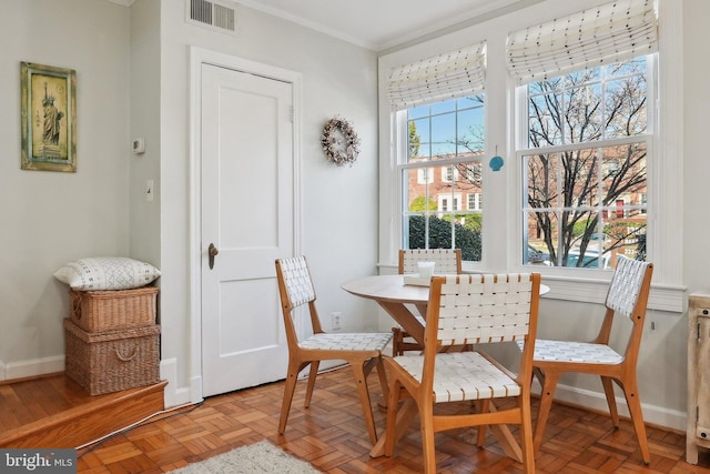 dining area with visible vents, breakfast area, crown molding, and baseboards