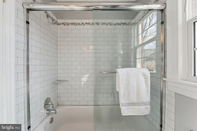 bathroom with bath / shower combo with glass door