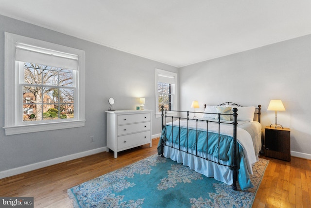 bedroom with wood finished floors and baseboards