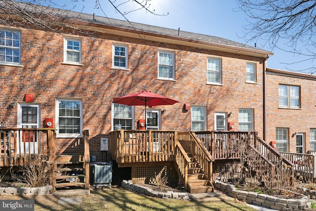 back of house with brick siding, central air condition unit, stairs, and a deck