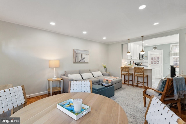 living area with crown molding, recessed lighting, and baseboards