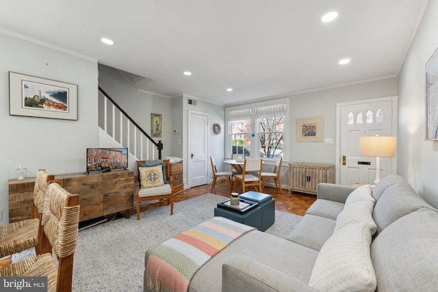 living room featuring visible vents, stairs, radiator heating unit, ornamental molding, and recessed lighting