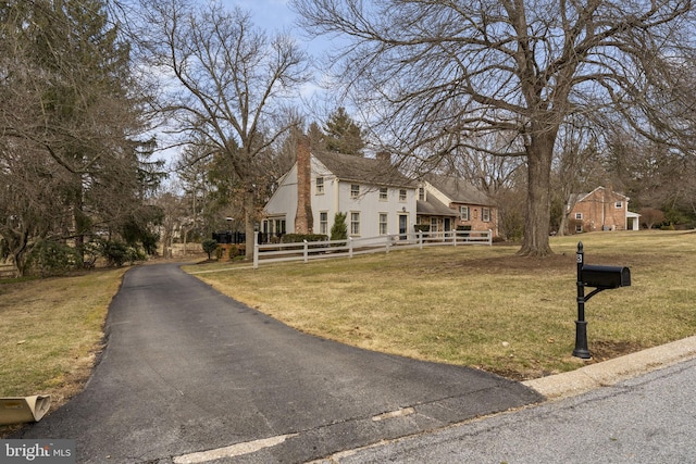 view of front of property with fence and a front lawn