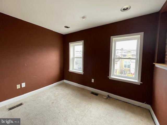 unfurnished room with visible vents, baseboards, and carpet floors