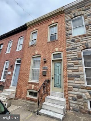 view of property featuring entry steps and brick siding