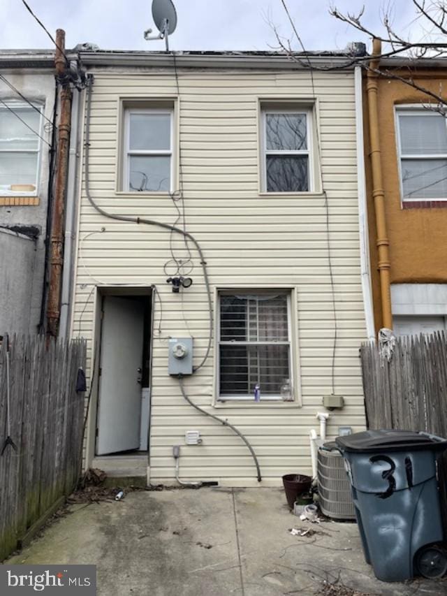 rear view of house with central air condition unit, a patio area, and fence