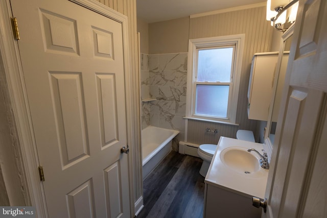 bathroom featuring bathing tub / shower combination, toilet, wood finished floors, vanity, and a baseboard heating unit