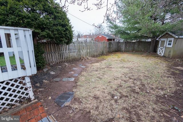 view of yard featuring an outbuilding, a shed, and a fenced backyard