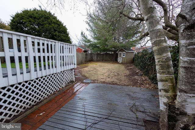 wooden terrace with an outbuilding, a fenced backyard, and a shed