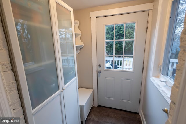 doorway to outside with dark tile patterned floors