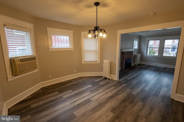 unfurnished dining area with radiator heating unit, a fireplace, and dark wood finished floors