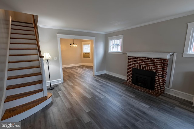 unfurnished living room with ornamental molding, a brick fireplace, stairway, and wood finished floors