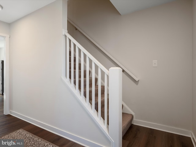 stairway featuring baseboards and wood finished floors