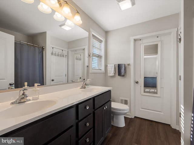 bathroom with toilet, visible vents, and a sink