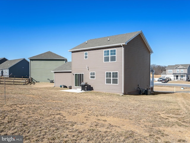 back of property with a patio, a yard, and fence