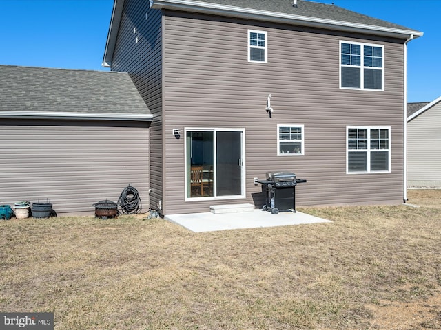 rear view of house featuring a yard, a patio, and roof with shingles