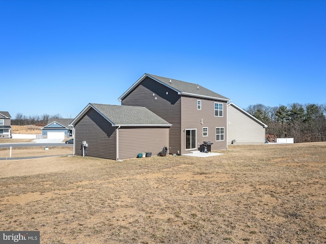 back of house featuring roof with shingles and a patio