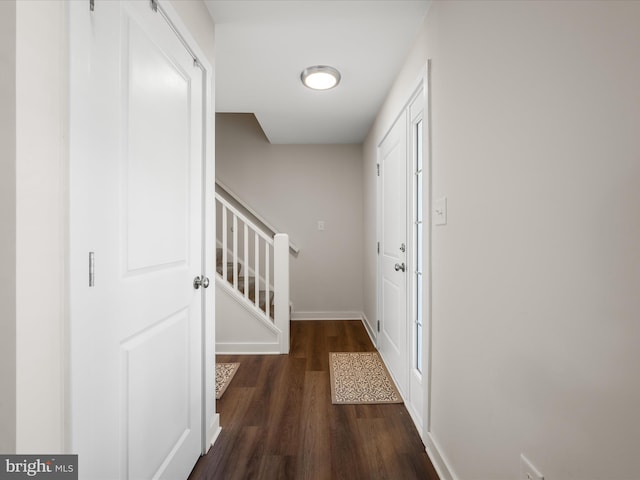 entryway featuring baseboards, stairway, and wood finished floors