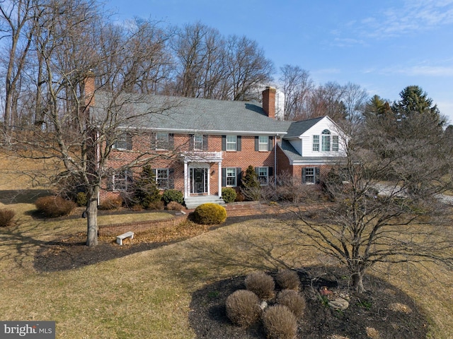 colonial-style house with brick siding and a chimney