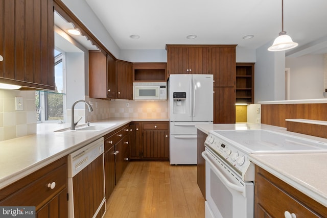 kitchen with white appliances, light countertops, light wood-style floors, open shelves, and a sink