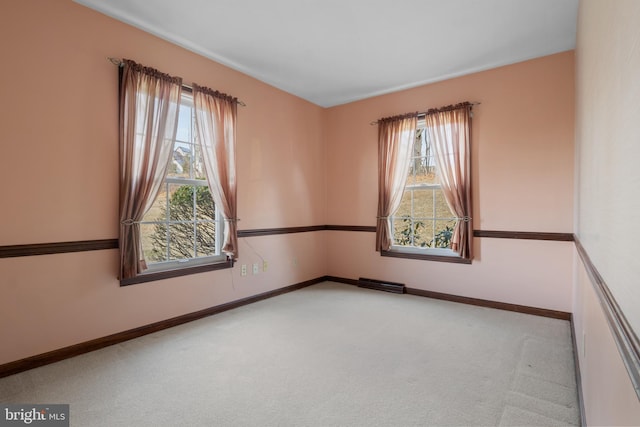 carpeted spare room with visible vents and baseboards