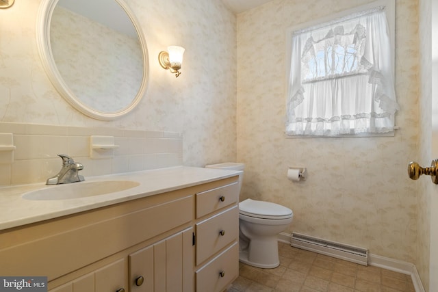 bathroom with toilet, wallpapered walls, a baseboard heating unit, and vanity